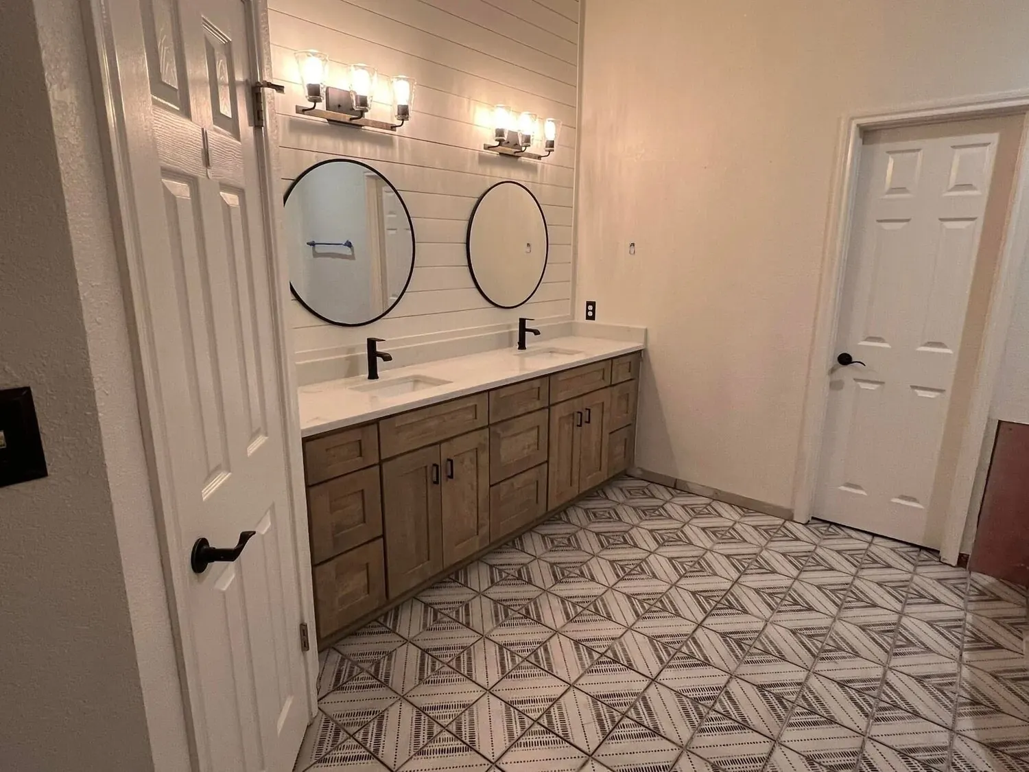 Bathroom after remodel with double vanity and patterned tile