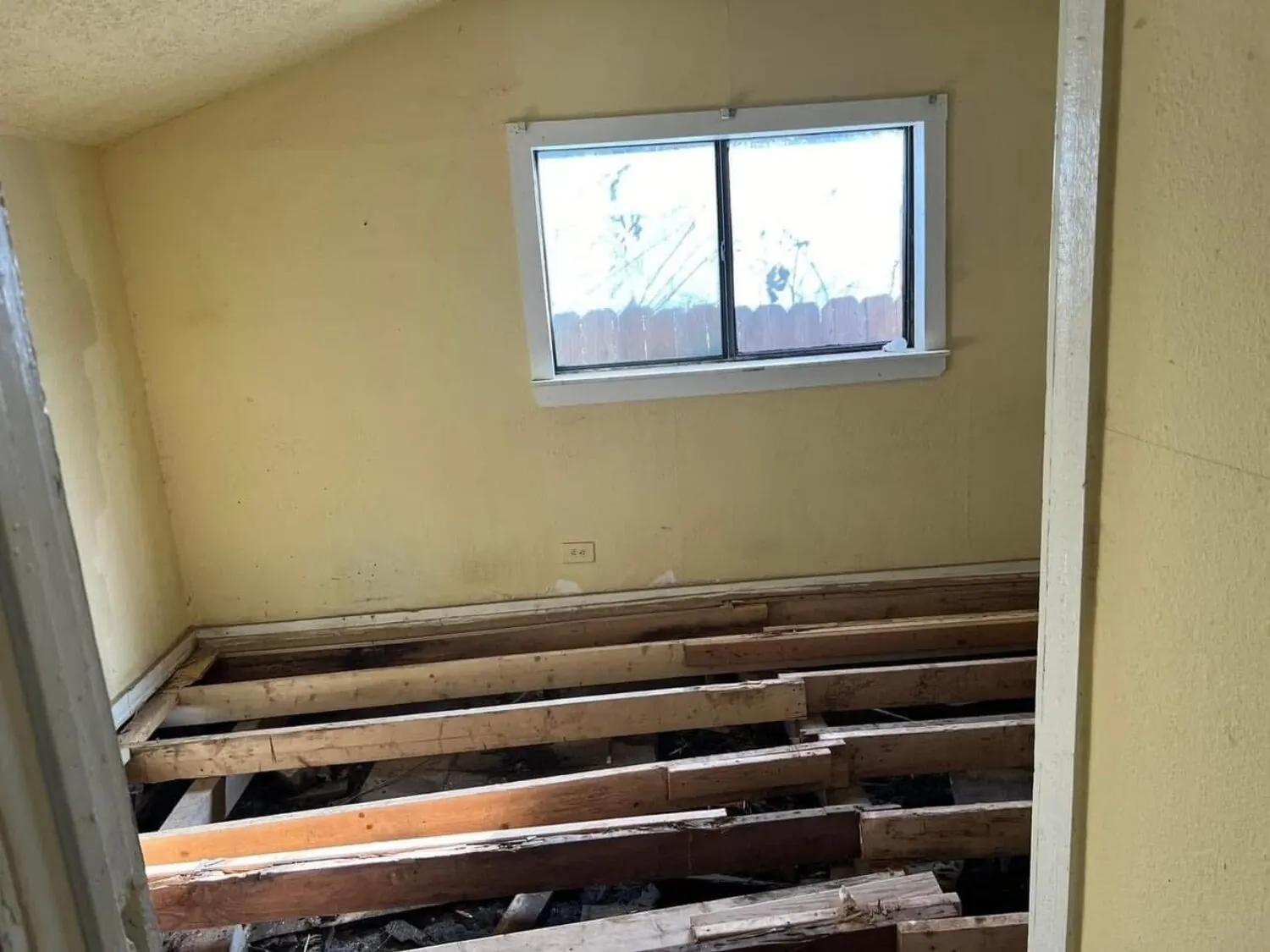 Room before remodel with floor opened during demo